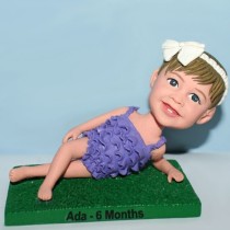 Little Girl Laying On The Grass Bobblehead